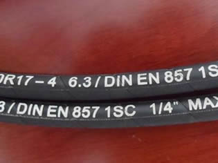 Two EN 857 1SC steel wire reinforced hydraulic hoses whose inner diameter is 1/4 inch are on the table.