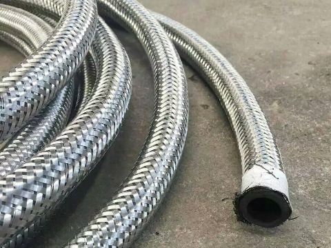 Braided stainless steel armoured hoses are placed on the ground.