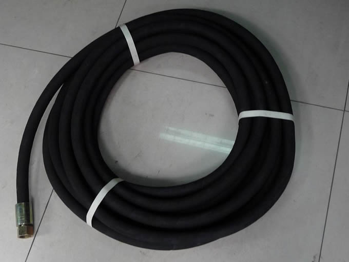 A bundle of black high pressure air hose is on the floor.