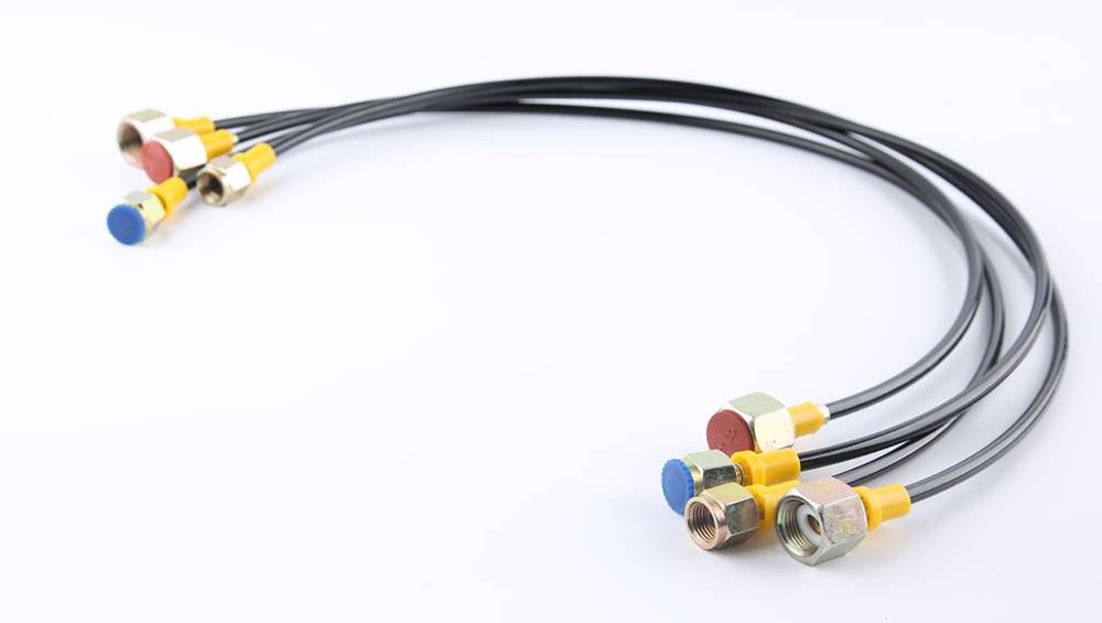 Four fiber reinforced nylon resin hose on the gray background with metal connectors.