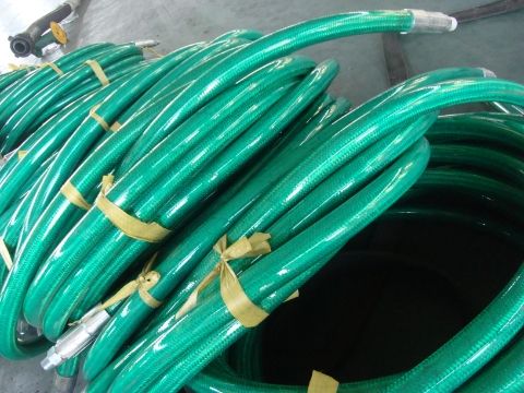 Many polymer armoured BOP hoses are placed on the ground.