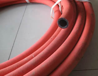 A roll of steam hose is on the floor.