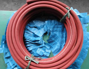A bundle of red steam hose is on the floor.